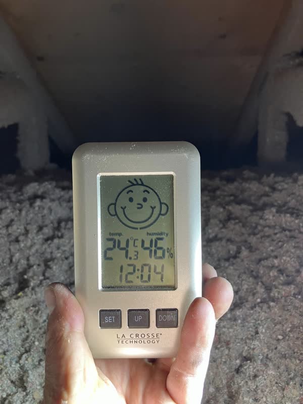 Hygrometer reading a cozy 24°C in a freshly insulated attic