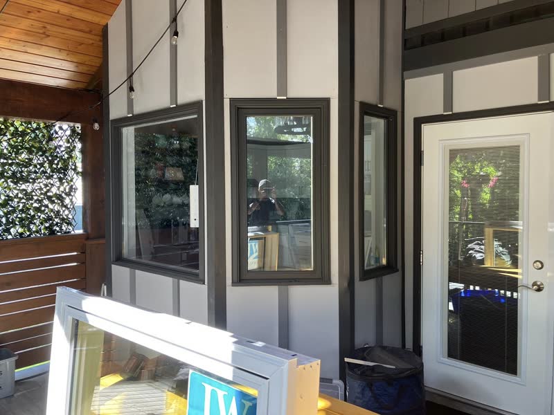 Black-frame casement windows and a glass door on a covered porch