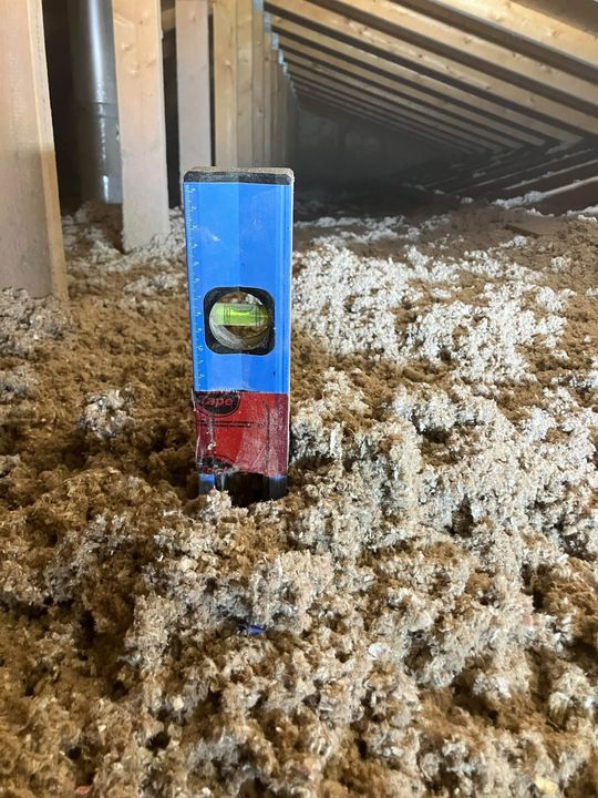Level marking the depth of new blown-in cellulose