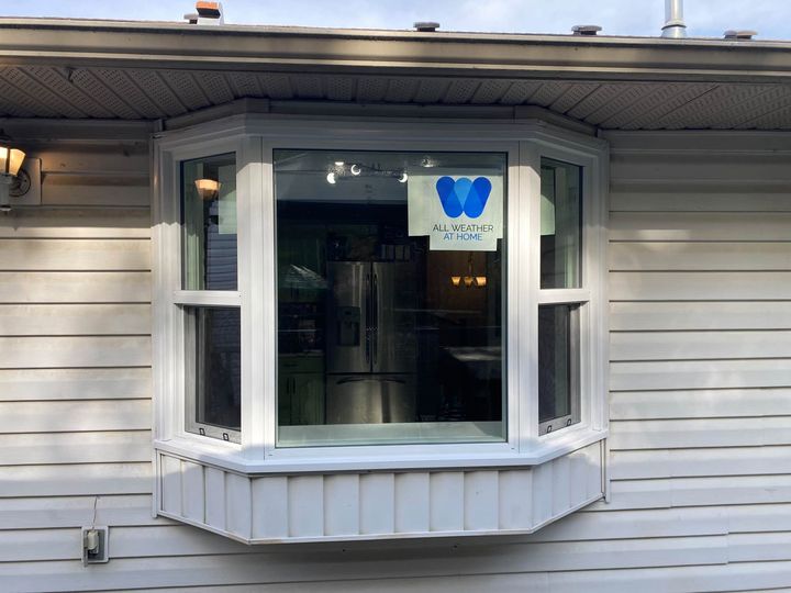 New white bay window installed on white vinyl siding