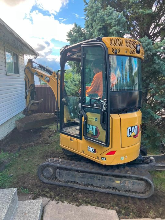Excavator digging at the foundation by the front steps