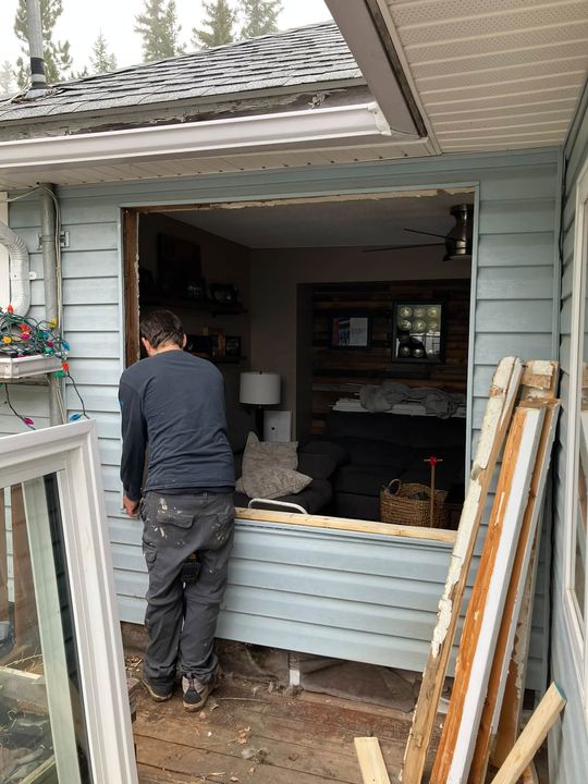 Crew installing the patio door, opening exposed to the room