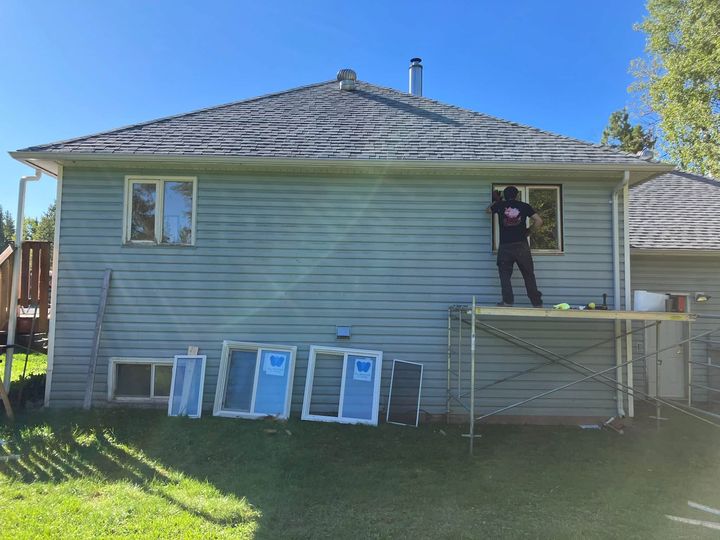 Back of the rural home with an installer on staging