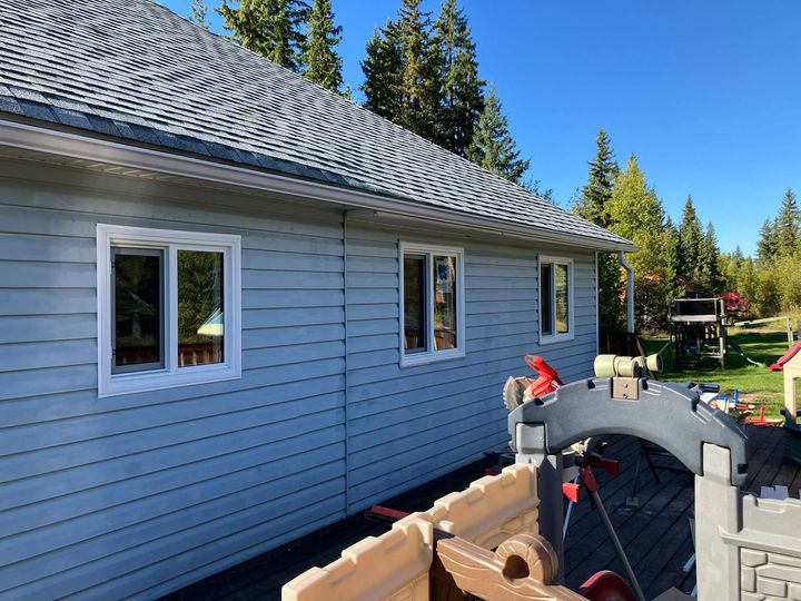 Side of the rural home with the new windows installed