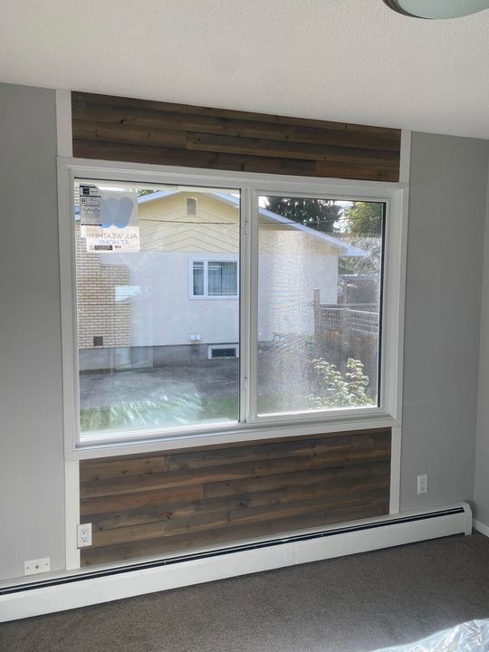 New window in a bedroom with a wood accent wall