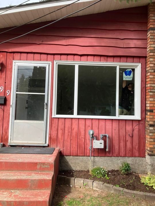 Finished living room window on a red-sided house