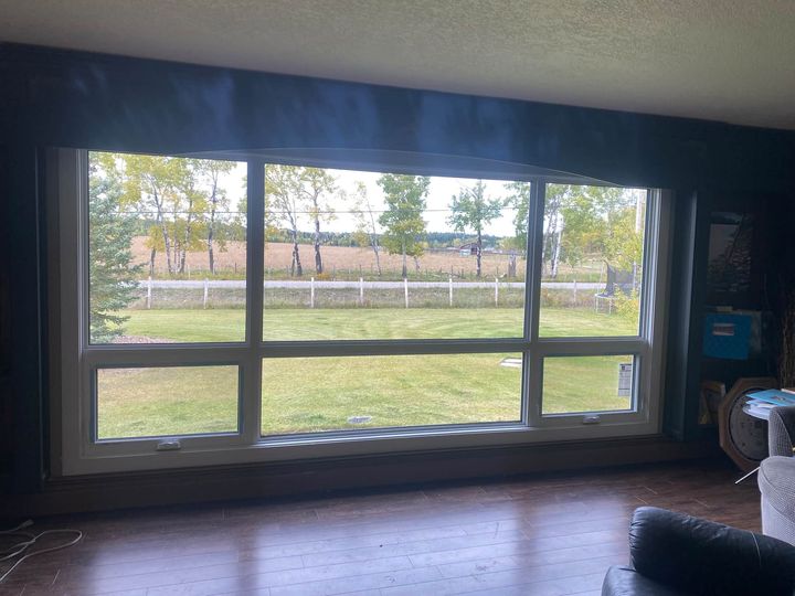 Huge new triple-pane picture window looking out over a large yard