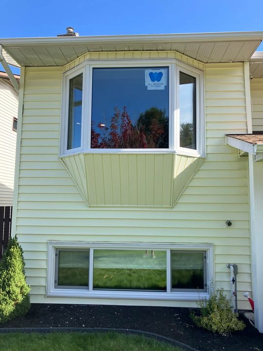 Finished triple-pane bay window on a yellow-sided home in Prince George